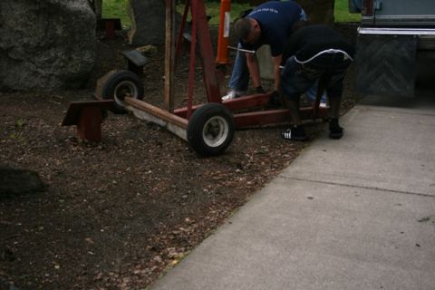 1990 Chevrolet Suburban - Men are moving an engine hoist. The vehicle in the background is partially visible.