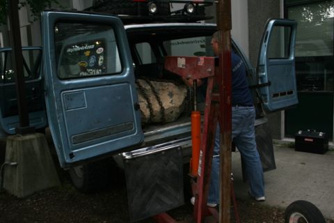 1990 Chevrolet Suburban - A man loads a large rock into the back of a blue 1990 Chevrolet Suburban.