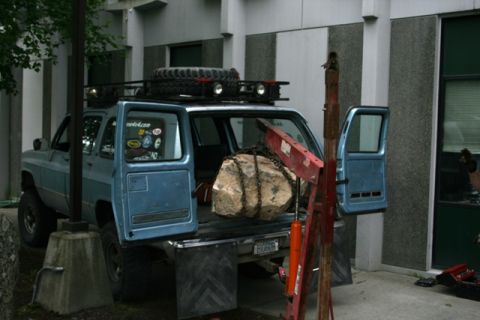 1990 Chevrolet Suburban - Loading a large rock into a blue 1990 Chevrolet Suburban using an engine hoist.