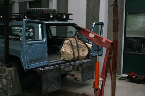 1990 Chevrolet Suburban - A blue 1990 Chevrolet Suburban is being loaded with a large rock using an engine hoist.