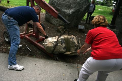 1990 Chevrolet Suburban - Two people and a child observe as a rock is moved with a lifting device.