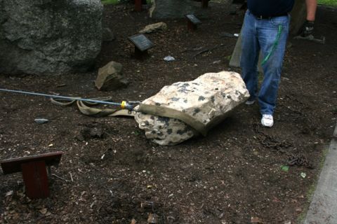 1990 Chevrolet Suburban - A large rock is being moved with a strap and cable, with a person in jeans standing nearby.