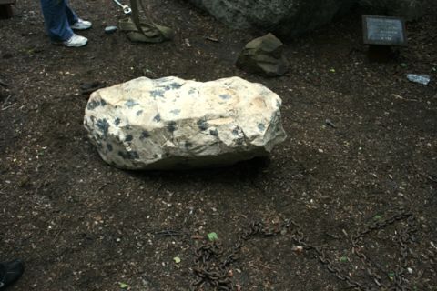 1990 Chevrolet Suburban - A rock garden scene features a large, speckled boulder with chains scattered on the dirt ground.