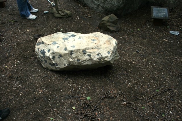 Rock garden with a large speckled boulder and chains on the ground