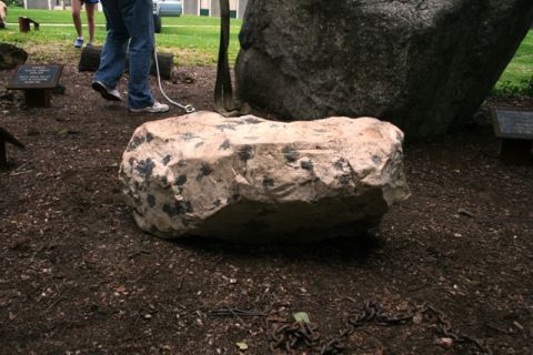 1990 Chevrolet Suburban - A large rock with dark inclusions is displayed outdoors, with chains visible on the ground.
