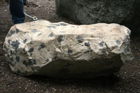 1990 Chevrolet Suburban - A large, textured boulder sits on the ground, partially shaded.
