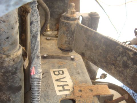 Close-up of rusty vehicle suspension parts with a label reading BVH