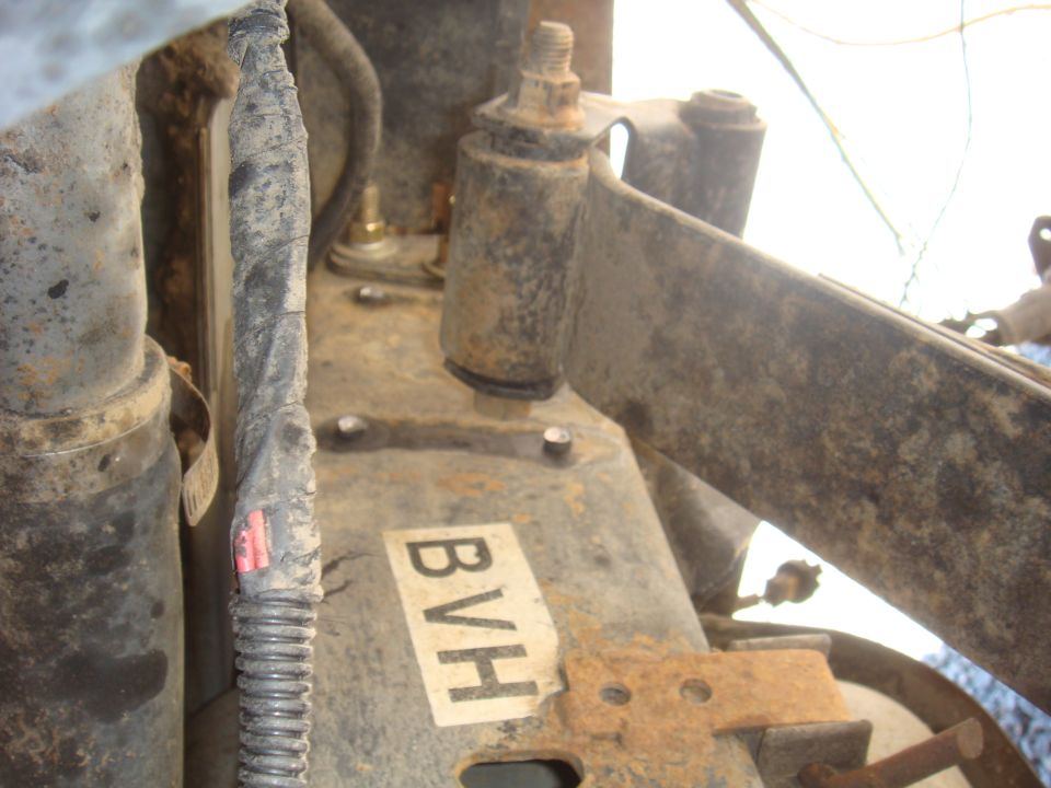 Close-up of rusty vehicle suspension parts with a label reading BVH