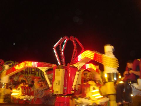 Carnival ride with red and yellow lights at night
