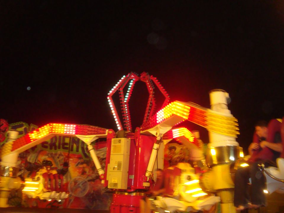 Carnival ride with red and yellow lights at night