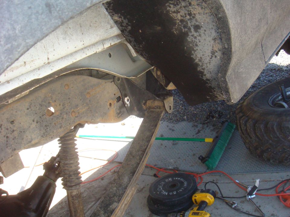 Vehicle frame and suspension components with a tire visible on the right