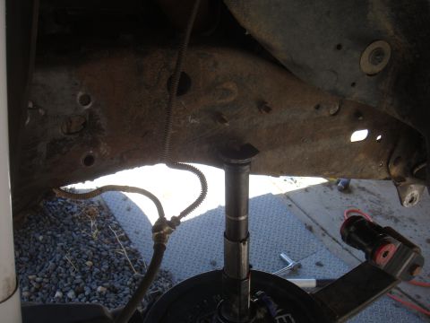 Rusty vehicle frame with suspension parts and brake line