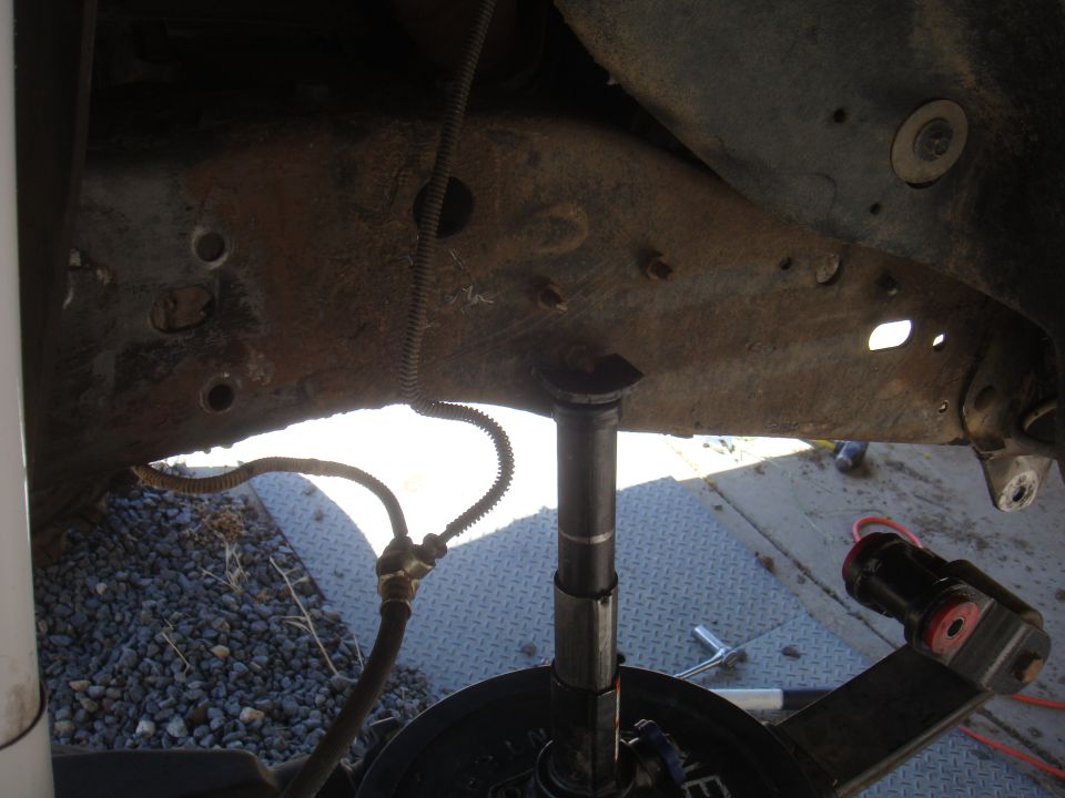 Rusty vehicle frame with suspension parts and brake line