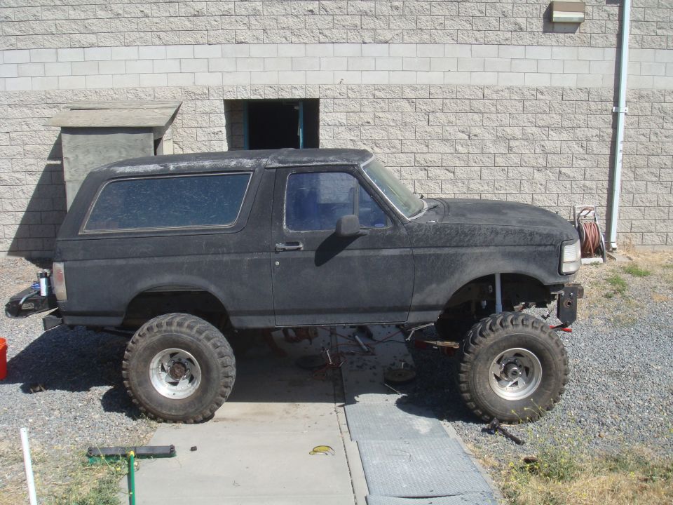 Black 1992 Ford Bronco side view, lifted with large tires