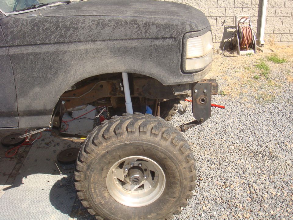 Front fender and tire of a lifted Ford truck, possibly F-150 or Bronco, with aftermarket bumper bracket