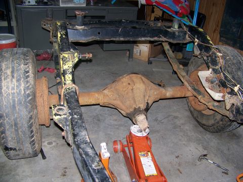 1992 Jeep YJ - The frame and rear axle assembly of a Jeep YJ are visible, supported by an orange jack.
