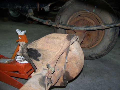1992 Jeep YJ - Close-up view of a vehicle's rear axle and leaf spring assembly, supported by orange jack stands.