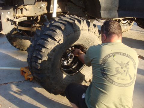 Man working on a large off-road tire and wheel