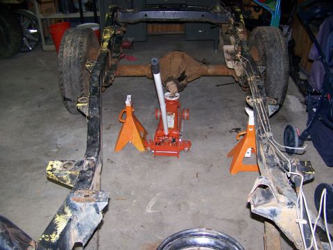 1992 Jeep YJ - The chassis of a vehicle is elevated on jack stands, with the rear axle assembly visible.