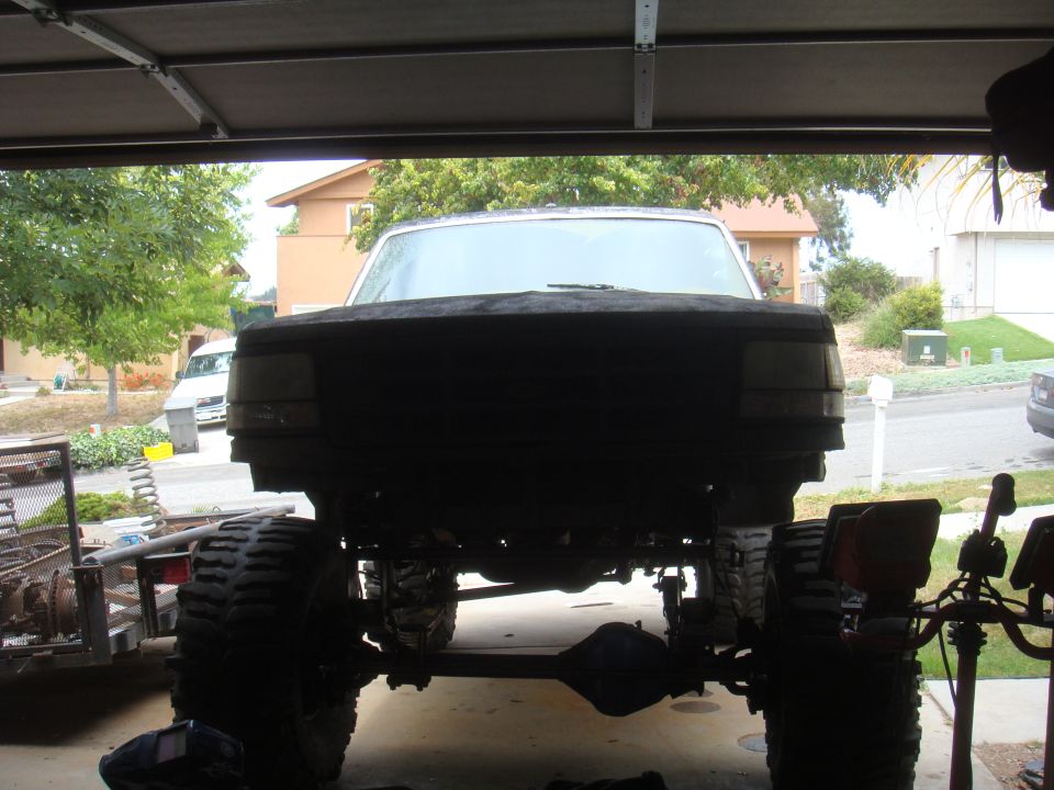 1992 Ford Bronco front view, lifted with large tires, in a garage