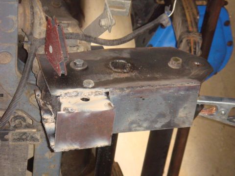 Welded metal bracket attached to vehicle frame with bolts and wiring
