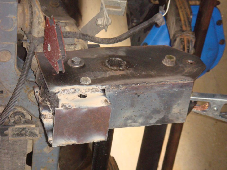 Welded metal bracket attached to vehicle frame with bolts and wiring