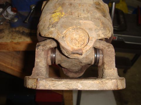close-up of a rusty driveshaft u-joint in a vise