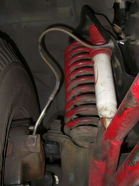 1990 Ford Bronco - The image shows the brake line, coil spring, and shock absorber of a vehicle's suspension system.