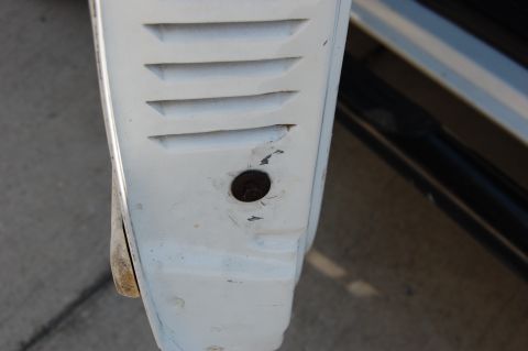 1994 Ford Bronco - Close-up of a white vehicle's fender shows horizontal vents and a bolt. The registry claims 1994 Ford Bronco.