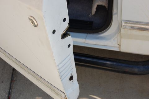 1994 Ford Bronco - Close-up of a white SUV's open door, showing the latch mechanism and a glimpse of the interior.