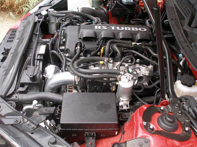 Engine bay with RS TURBO cam cover, polished charge piping and black airbox in a red car