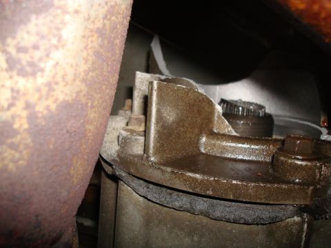 1996 Ford Bronco - Detail of a vehicle's mechanical component, possibly transmission or transfer case, with a prominent rusty exhaust pipe. Supermotors.net lo…
