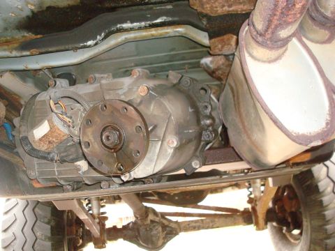 1996 Ford Bronco - This photo shows the underside of a vehicle, focusing on the transfer case and exhaust system, with visible rust and significant rust.