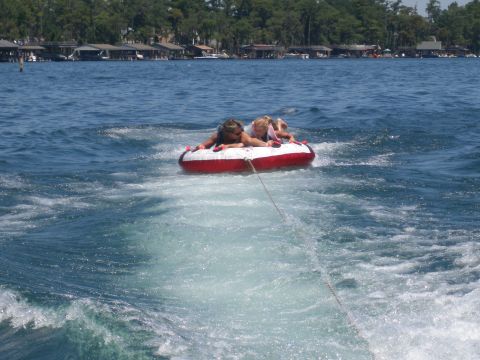 1998 Chevrolet Silverado 1500 - Children enjoy tubing on a lake, with houses visible in the background.