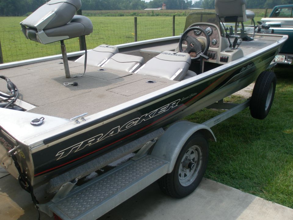 Green and black Bass Tracker fishing boat on a single-axle trailer