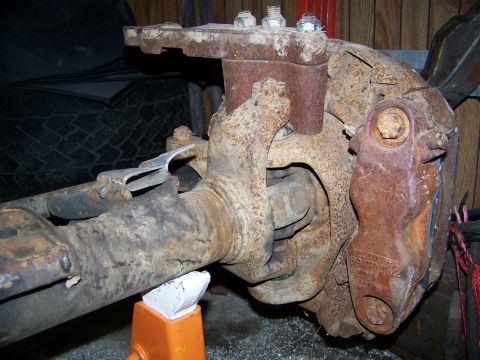 1992 Jeep YJ - Close-up of a heavily rusted front axle and brake assembly, likely from an older vehicle.