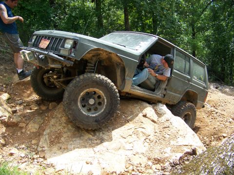 1992 Jeep YJ - Green Jeep Cherokee XJ navigating rocky terrain during an off-road excursion.