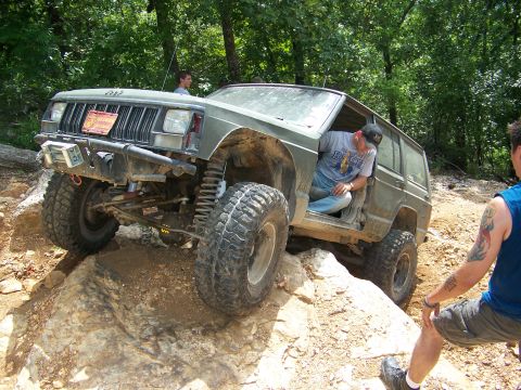 1992 Jeep YJ - This modified Jeep Cherokee XJ navigates a challenging off-road course, its lifted suspension and tires.
