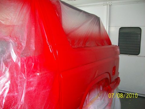 1985 Ford Bronco - Vehicle undergoing a fresh coat of red paint in a spray booth.