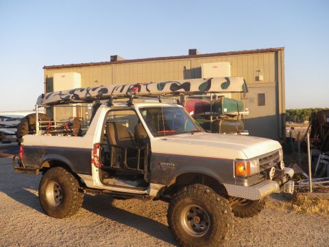1991 Ford Bronco - This 1991 Ford Bronco is equipped with a roof rack carrying multiple canoes and has its doors removed.