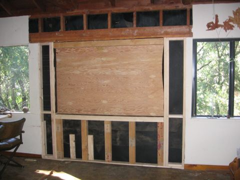 1989 Ford Bronco - The room appears to be undergoing renovation, with unfinished walls and a large window overlooking trees.