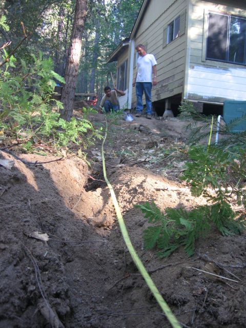 1989 Ford Bronco - A scene depicting two individuals engaged in work near a house, with a yellow tape measure laid out on the disturbed earth.