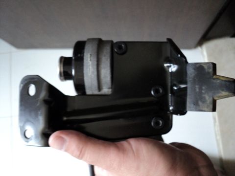 2001 Mercury Grand Marquis - A black cruise control module with a metal bracket is held by a hand.