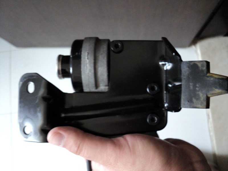 Black cruise control module with metal bracket held by a hand