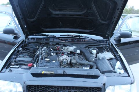 2007 Ford Crown Victoria - The engine bay of a 2007 Ford Crown Victoria is visible with the hood open, revealing the engine and various parts.