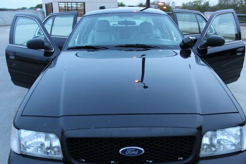 2007 Ford Crown Victoria - Front view of a black 2007 Ford Crown Victoria, its interior with all four doors ajar.