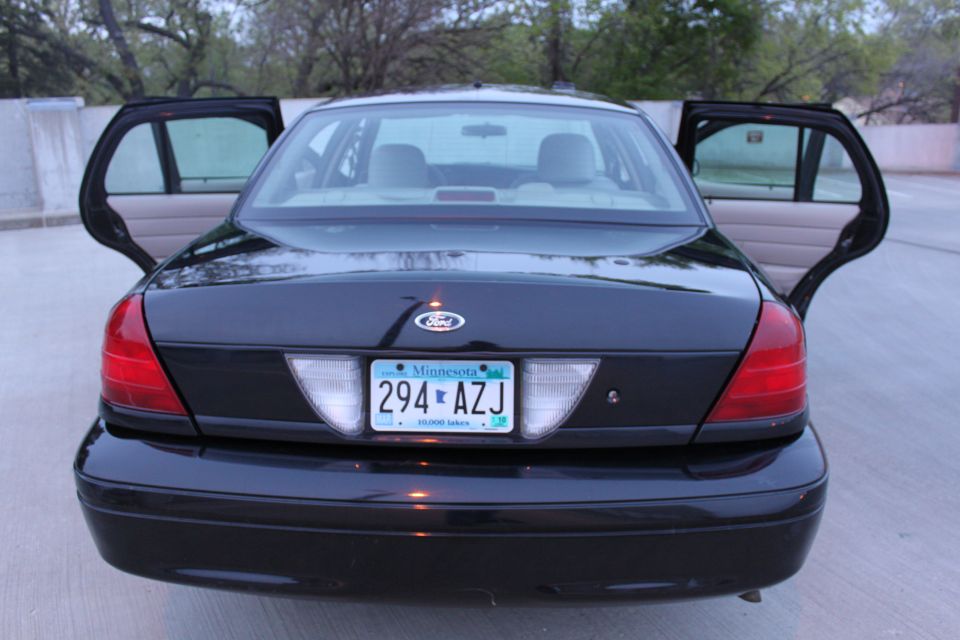 Rear view of black Ford Crown Victoria with doors open and Minnesota plate 294 AZJ