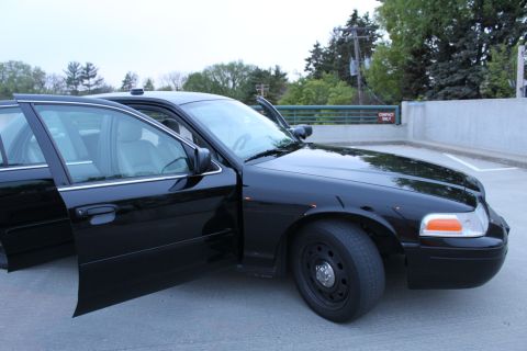 2007 Ford Crown Victoria - A black 2007 Ford Crown Victoria sedan is shown with its doors ajar in a parking lot.