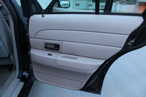 2007 Ford Crown Victoria - Interior view of the front passenger door panel on a 2007 Ford Crown Victoria, showing the armrest and door handle.
