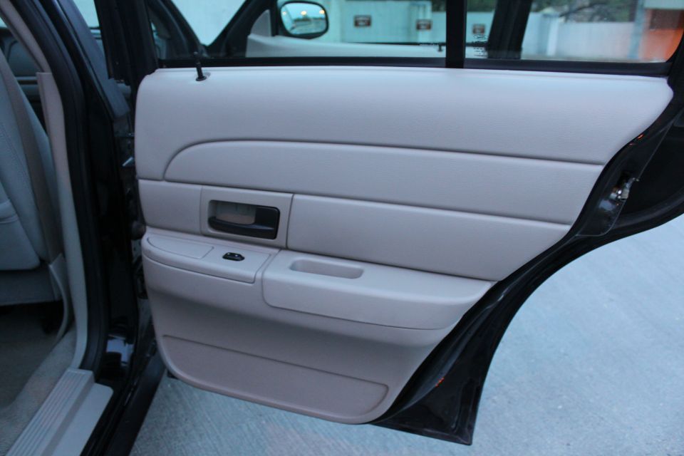 Light gray interior door panel with black handle and window controls. 2007 Ford Crown Victoria